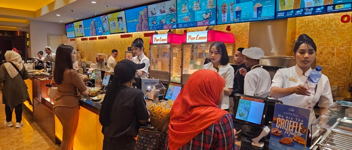 Customers purchasing F&B from a lineup of POS terminals